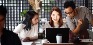 A group of employees around a laptop